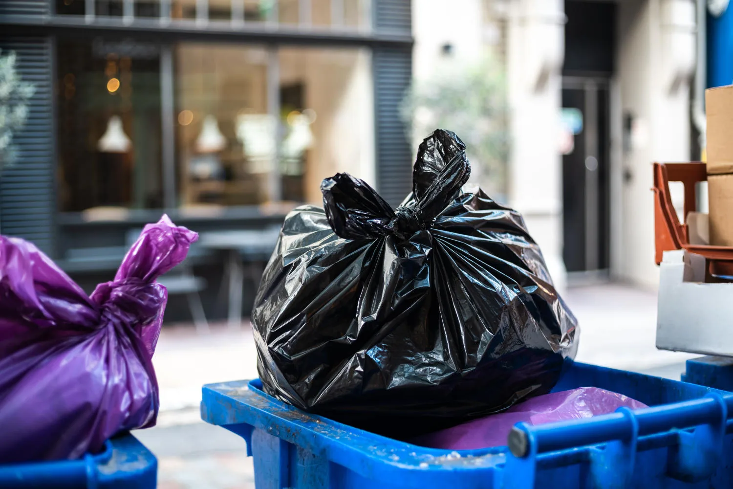 And black bags of trash on a garbage bin during daytime